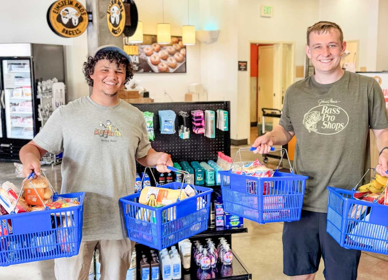Two Cal Poly students holding grocery baskets and shopping at Cal Poly's new on campus store in PCV.