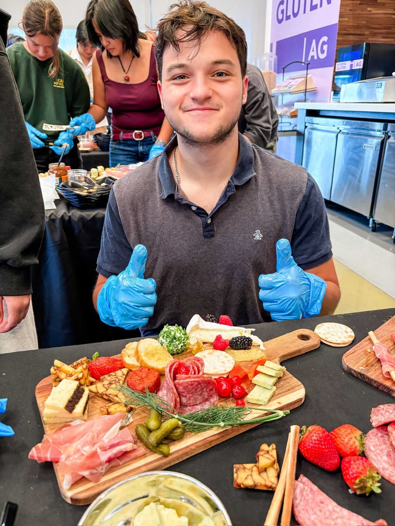 Student smiling with thumbs up behind his board.