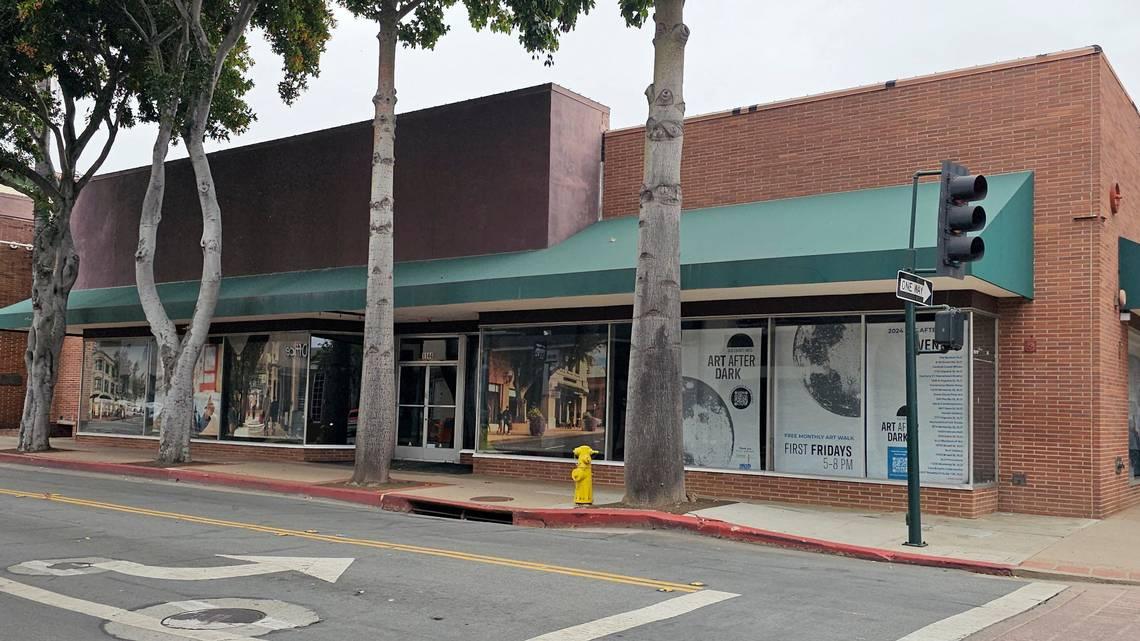 Street view of a brick building at 1144 Chorro Street in downtown San Luis Obispo, featuring large display windows promoting “Art After Dark” and shaded by trees along the sidewalk.