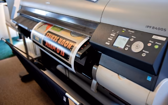 A large-format printer produces a colorful poster at Cal Poly Print and Copy Services.